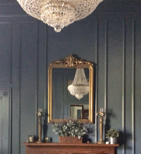 The reviewer's mirror, positioned on a wall directly across from a chandelier