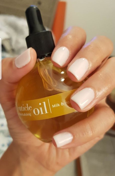 A reviewer showing off the milk- and honey-infused cuticle oil.