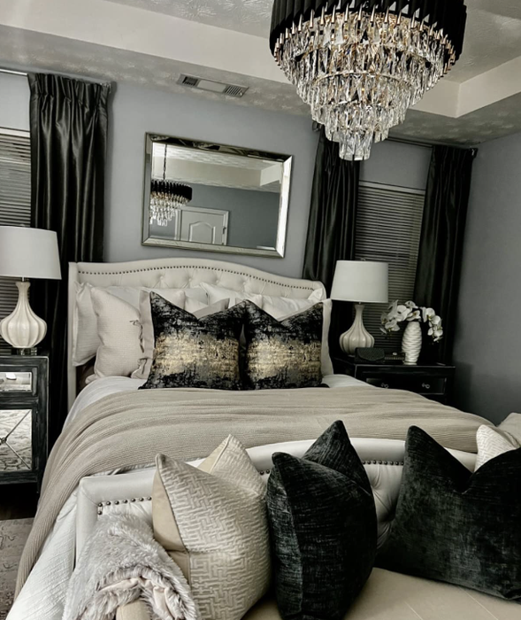 The reviewer's bedroom, with bedding that complements the gold and black chandelier