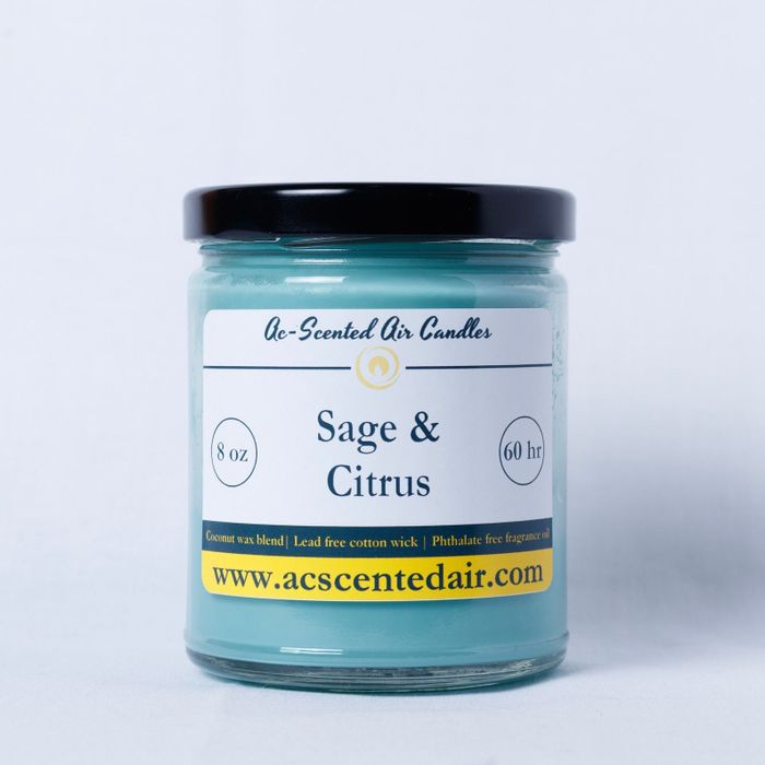 A Sage and Citrus-scented candle in a jar with a label highlighting features such as the 8 oz size and 60-hour burn time, alongside the website link.