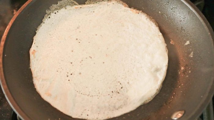 A thin egg white disc in a frying pan.