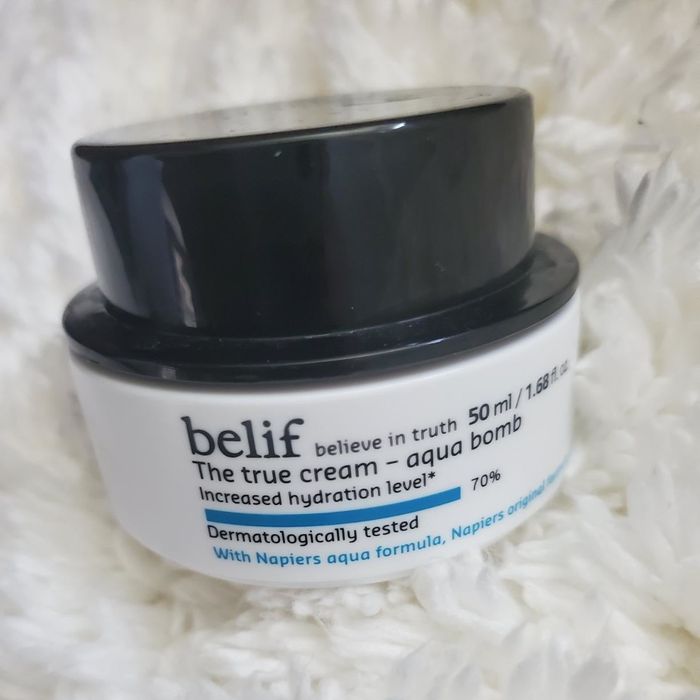 A photograph from a reviewer showcasing the black and white moisturizer container.