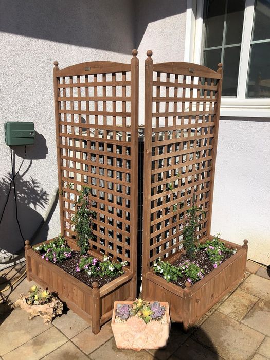 Wooden lattice planter boxes filled with a variety of colorful flowering plants, ideal for enriching your outdoor garden space