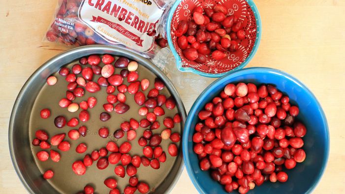 A pan and two bowls filled with cranberries – one for sorting, one for the keepers.