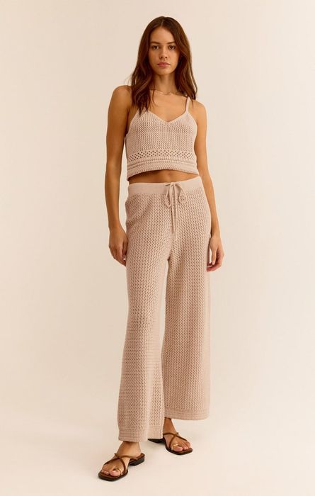 A model in a knit crop top and matching drawstring pants, posing for a fashion feature.