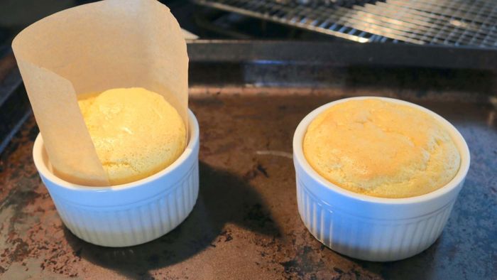 Two ramekins, each containing a soufflé pancake inside, ready to be enjoyed.