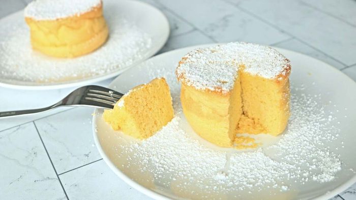 Fluffy pancakes, topped with a light dusting of powdered sugar, elegantly placed on a plate.