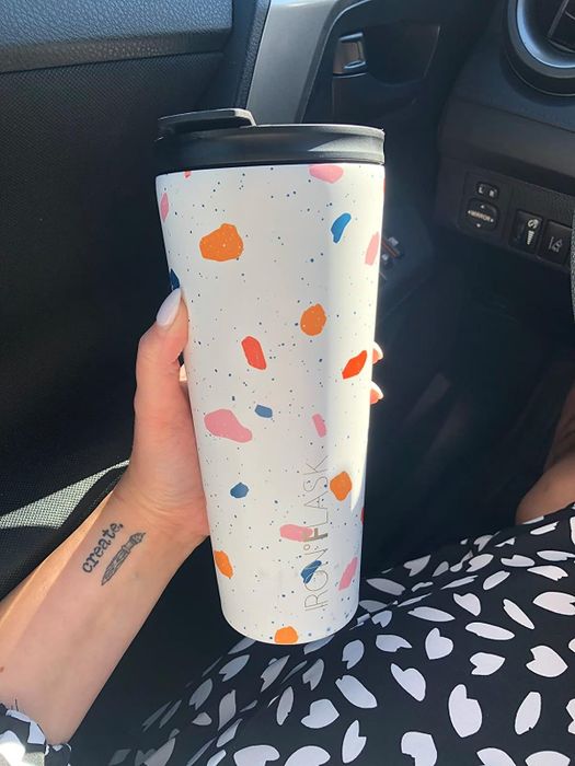 a reviewer holding a 20oz tumbler with a colorful speckled design