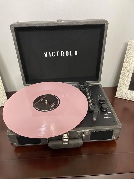 grey turntable with a pink vinyl record on it