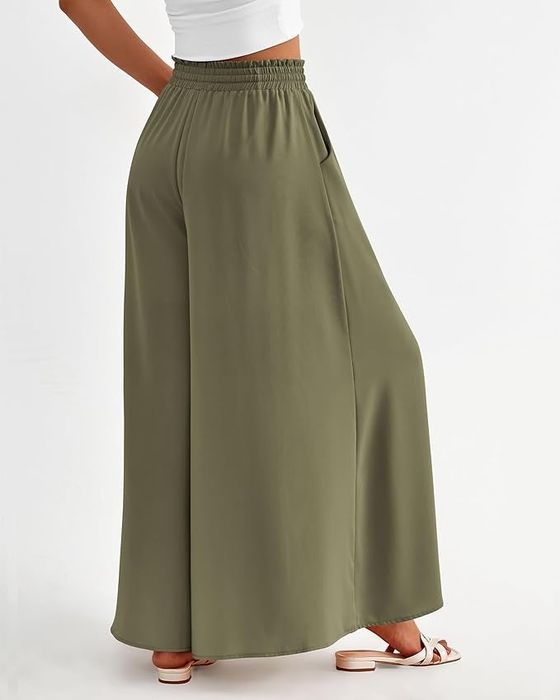 Green wide-legged pants with pleats, teamed with white sandals.