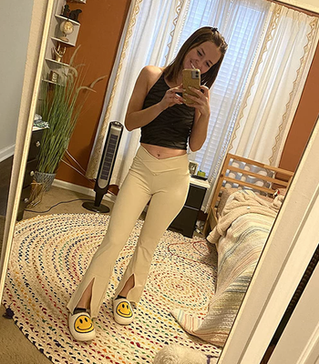 Reviewer models white V-waist flared leggings featuring slits at the bottom.