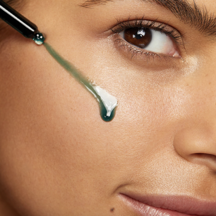 a model applying face oil using a dropper