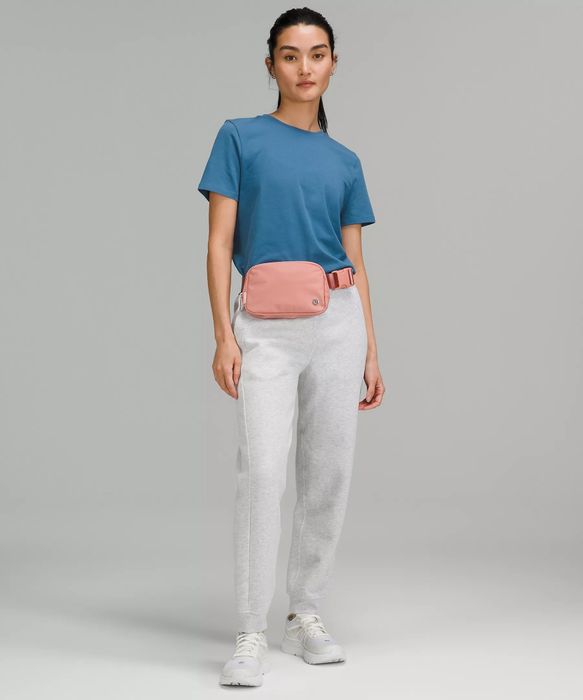 a model wearing a coral bag around their waist