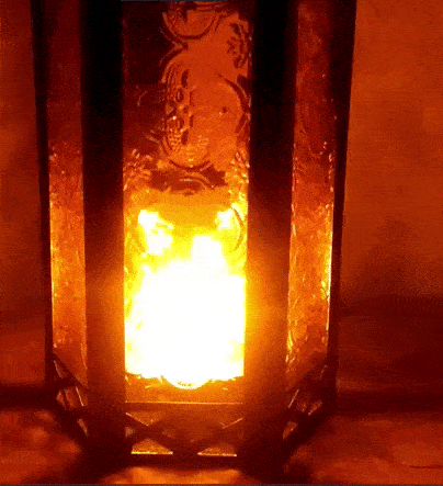 A gif of the amber lantern glowing at night with a candle flickering inside, creating a soft, mystical glow.