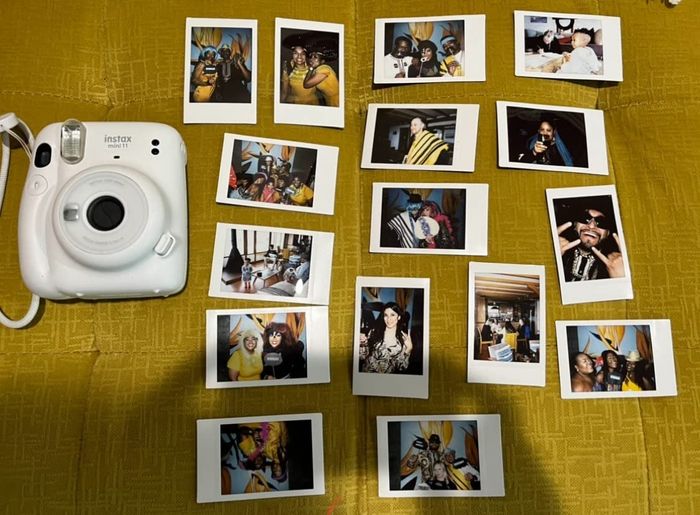 a white Polaroid camera surrounded by several printed photos