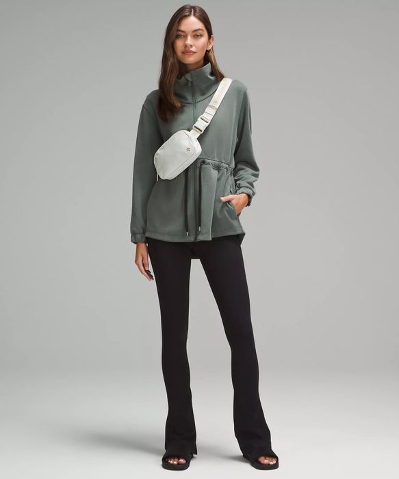 a model wearing a white bag slung across their shoulder
