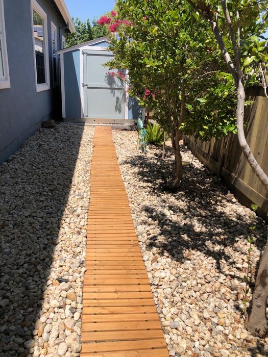 The reviewer's wooden path leads up to an outdoor shed