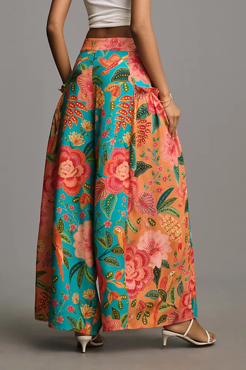 The model is seen from behind, wearing a floral-patterned skirt and heels.