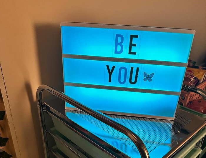 a light box glowing in blue with the words 'be you' displayed
