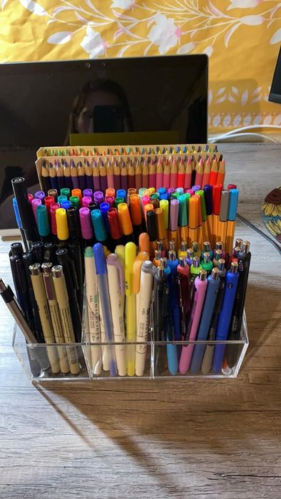 An acrylic desk organizer filled with vibrant pens