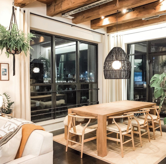 a reviewer’s photo of the chairs placed around a long rectangular solid wood table
