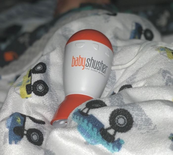 A reviewer shows their child peacefully sleeping with the white noise machine by their bedside.