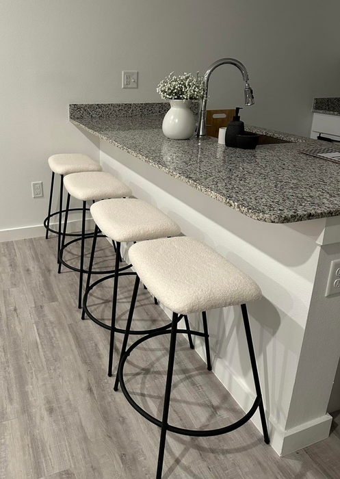A sleek kitchen island with three barstools, offering inspiration for contemporary home interiors
