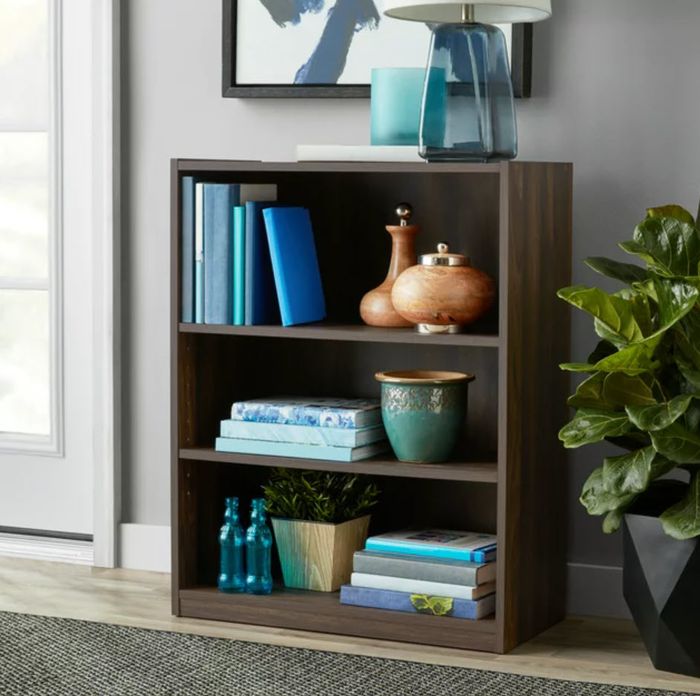 A bookshelf adorned with various decorative items and neatly arranged books in a room.