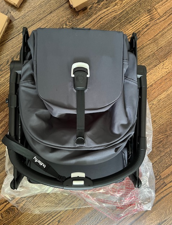 The same stroller folded into a compact, backpack-style shape.