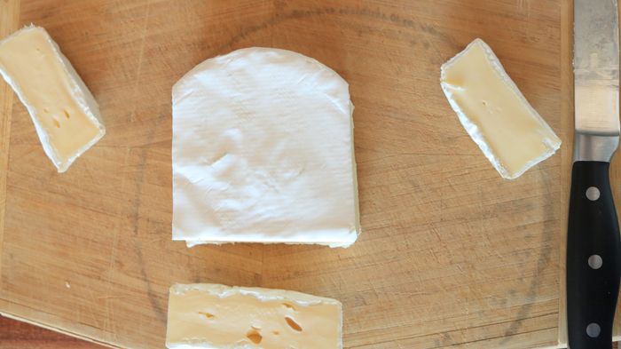 A wheel of brie with the sides and bottom trimmed off.