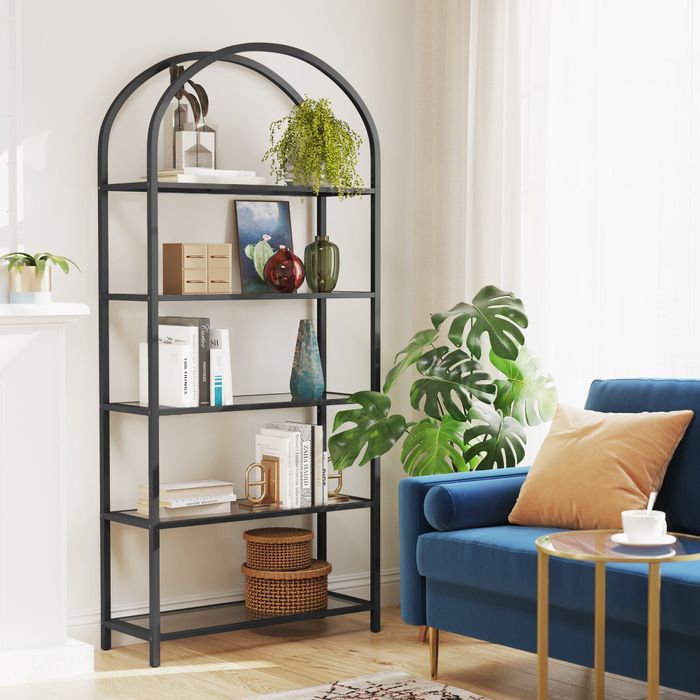 A contemporary living room featuring a bookshelf, lush plants, and a blue sofa, ideal for highlighting modern home decor trends