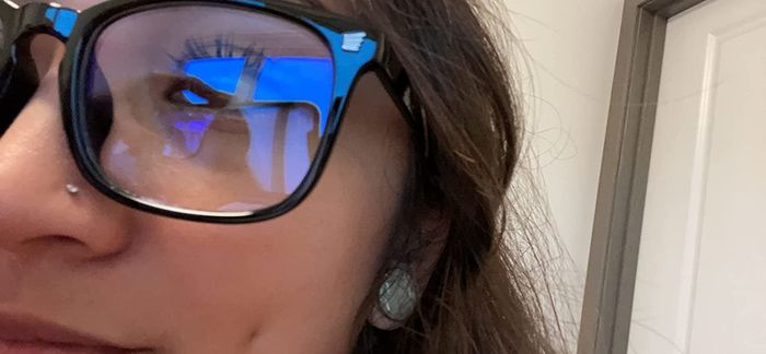 Close-up of a reviewer showcasing the blue light reflection on the glasses