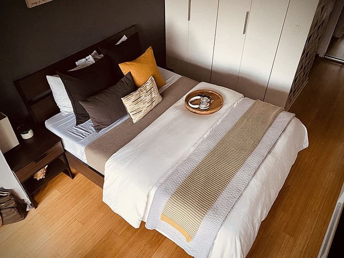 another reviewer’s bed showcasing the white duvet layered with cozy throw blankets