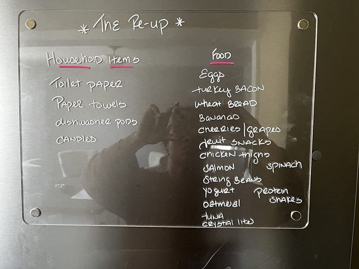 A reviewer’s photo of a clear dry-erase board mounted on a fridge.