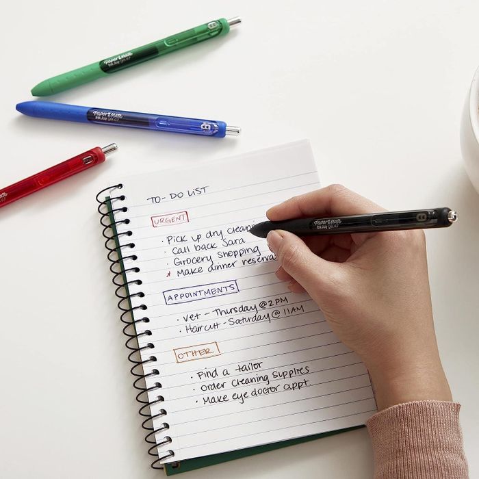 Model using colorful pens to write in a notebook