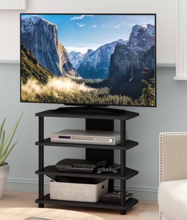 A TV on a stand showcasing a beautiful mountainous landscape, with a sofa and a plant placed nearby. No people are in sight, creating a peaceful scene.