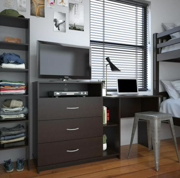 A neat and modern bedroom featuring a TV, computer on a desk, a window with blinds, and well-organized shelves.
