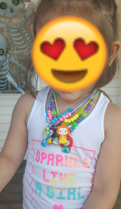 A reviewer's child proudly wearing the necklaces they created