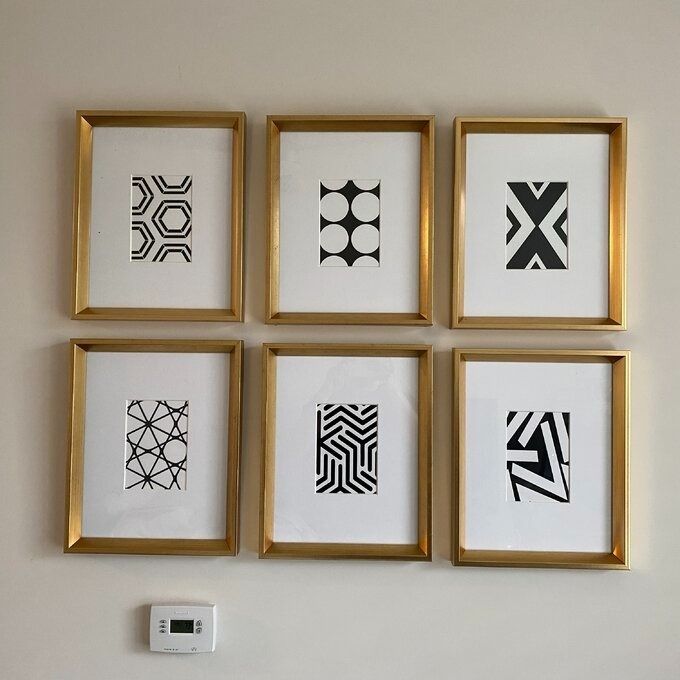 a reviewer photo showing the six framed prints arranged in two rows of three on a wall