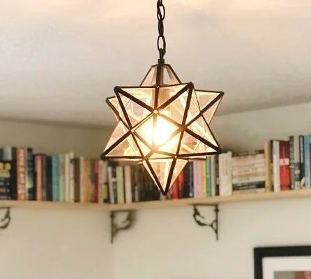 The pendant star light hanging gracefully in a bedroom, adding a touch of warmth.