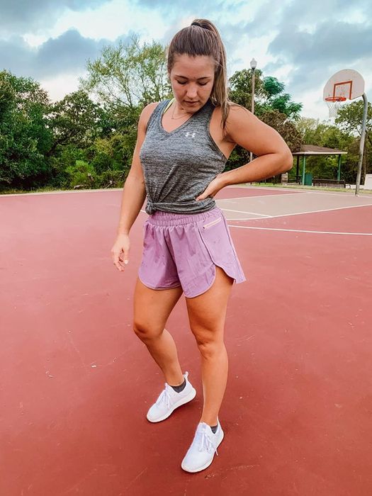 reviewer in light purple breezy run shorts paired with a gray tank and white sneakers