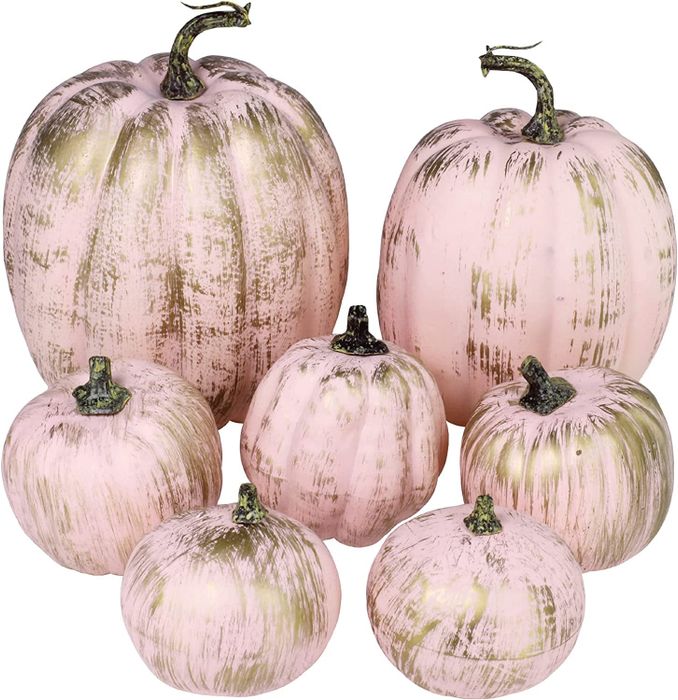 an assortment of pink and gold pumpkins in various sizes and shapes