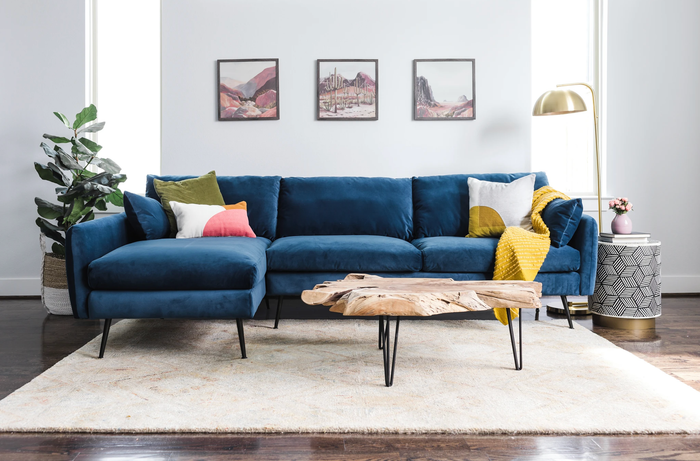 A navy blue velvet sectional from Albany Park is showcased in a cozy living room
