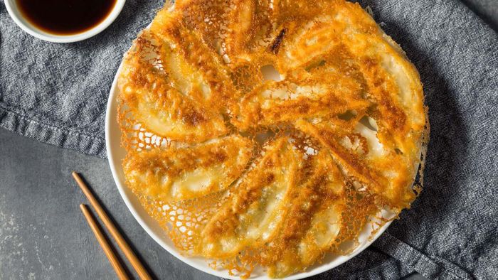 Dumplings with a delicate lace of crispy starch resting on the plate.