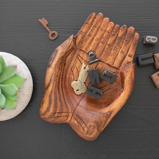 A wooden dish shaped like hands, holding keys, with a succulent and letter blocks placed beside it.