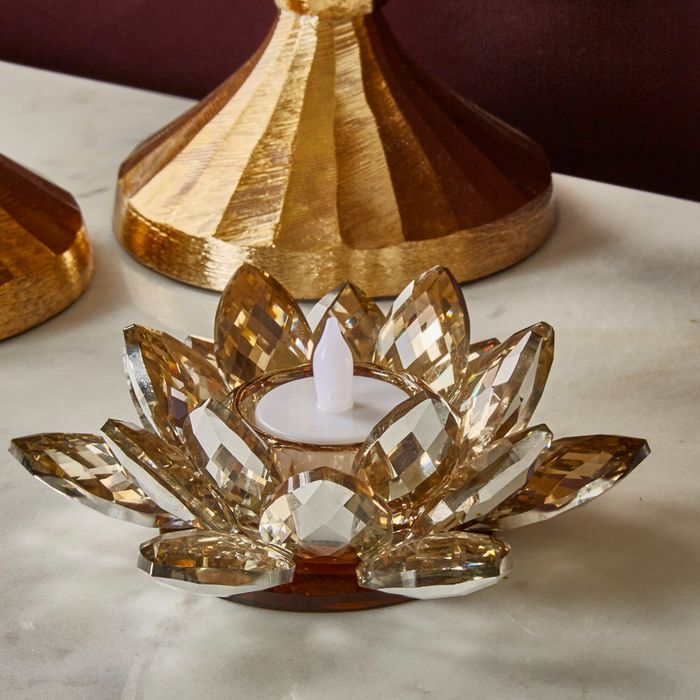 The elegant lotus-shaped candle holder resting on a table, adding an enchanting touch to the room.