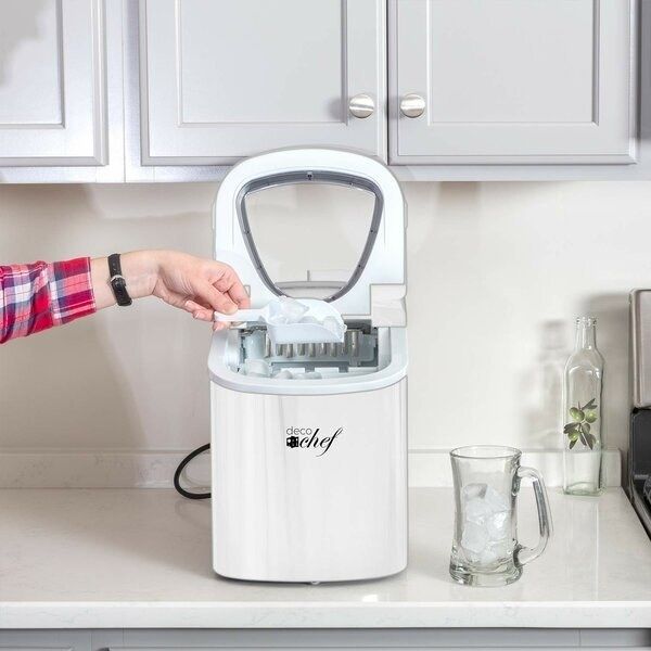 A white ice maker with a removable ice cube tray sitting on the kitchen counter.