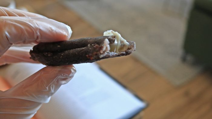 A hand holding a flauta that's been bitten into.