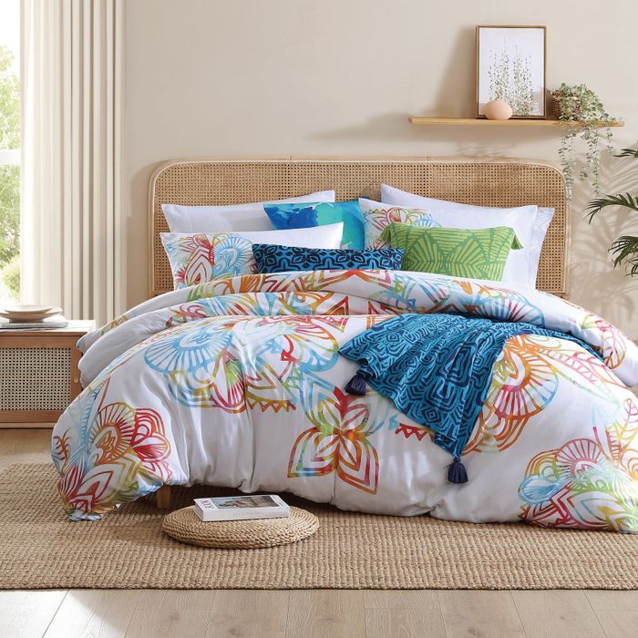 Bedroom showcasing a bed dressed with a patterned comforter and decorative pillows