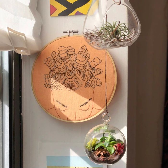 Embroidery artwork is showcased on a wall